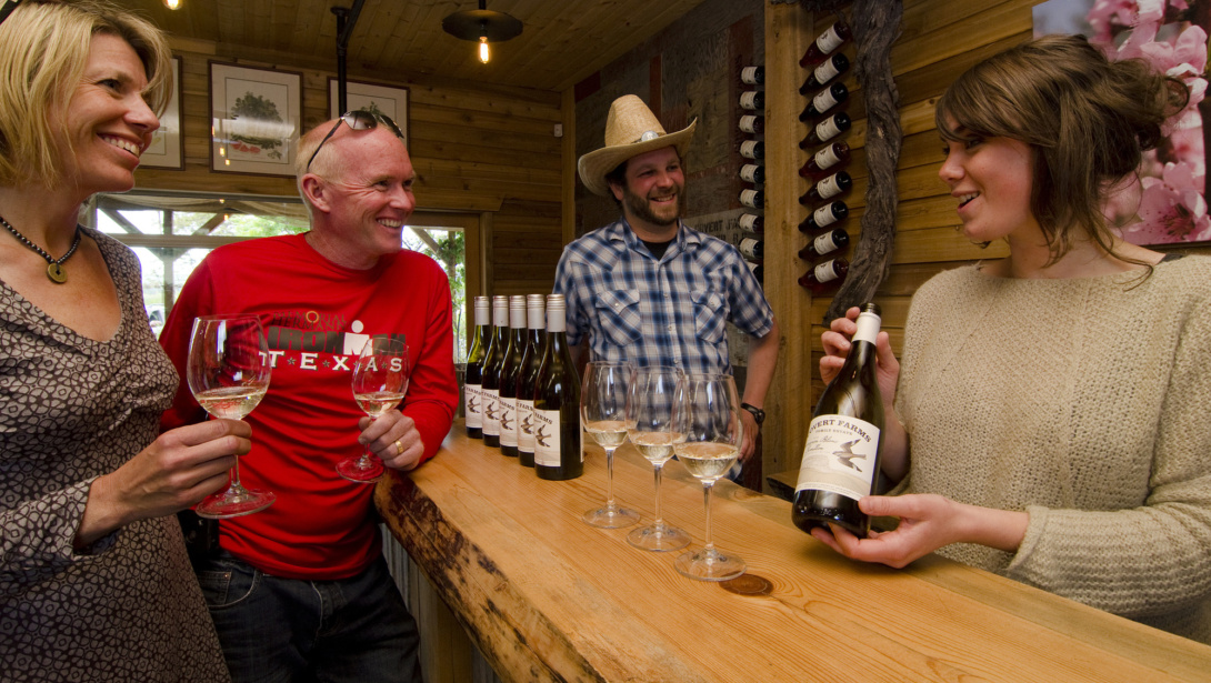 Sommelier showing a bottle of wine to visitors doing a wine-tasting.